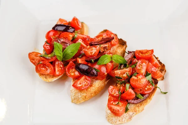 Bruschetta italiana com tomate picado, manjericão e azeitona — Fotografia de Stock