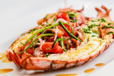 İtalyan mutfağı. Bütün ıstakoz pişmiş ve dilimlenmiş domates salatası ve beyaz tabakta sos ile yarım Served içinde
