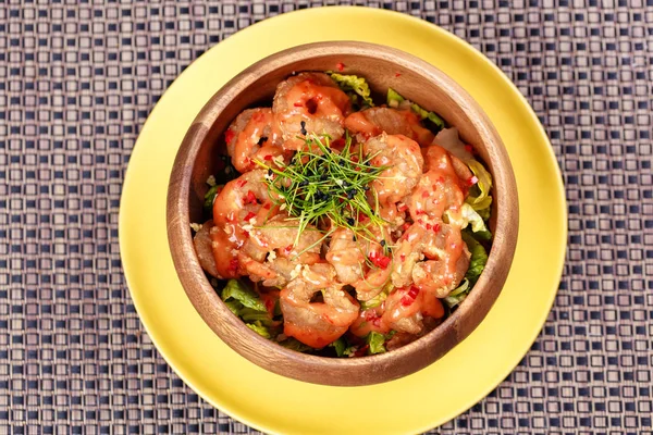 Fried crispy shrimp with leaves of greenery in the bowl