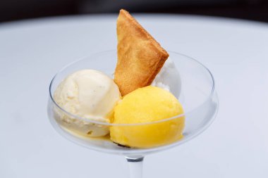 İki farklı top dondurma kek ve bir bardak tutku meyve.