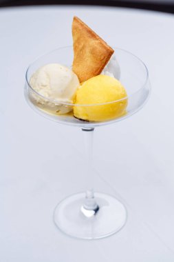 İki farklı top dondurma kek ve bir bardak tutku meyve.