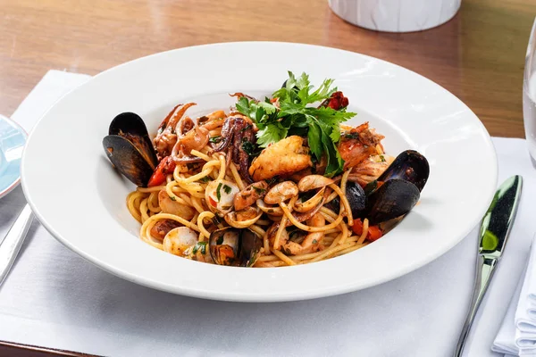 Spagetti deniz mahsulleri beyaz plaka üzerinde.