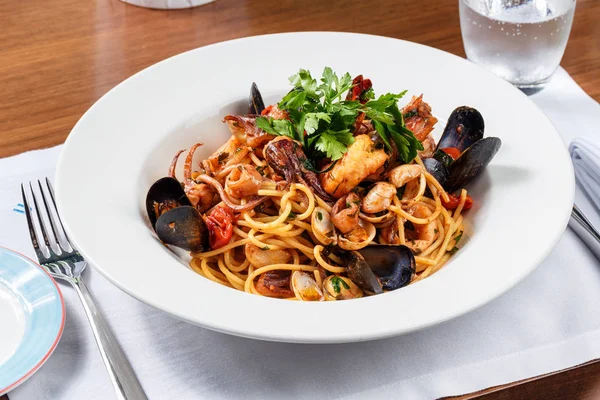 Spagetti deniz mahsulleri beyaz plaka üzerinde.