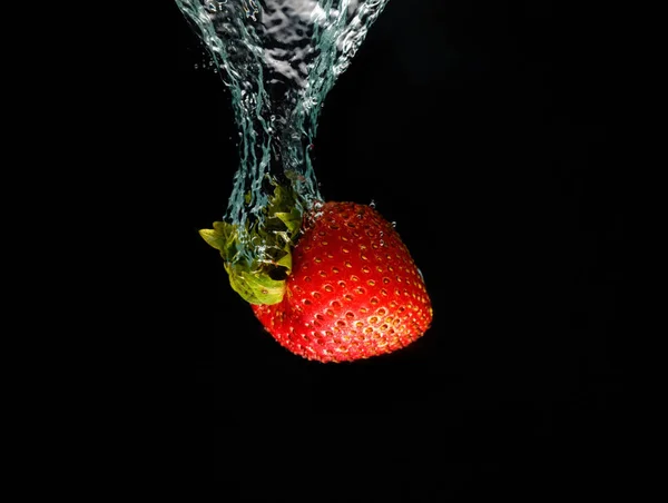 Una fragola che schizza in acqua — Foto Stock