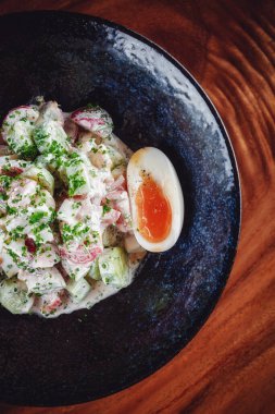 Ekşi kremayla karıştırılmış haşlanmış yumurtalı sebze salatası. 