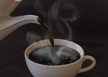 Koyu kahveyi çaydanlıktan fincana dök.