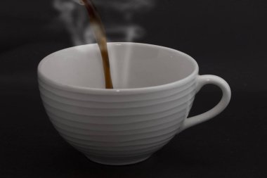 Koyu kahveyi çaydanlıktan fincana dök.