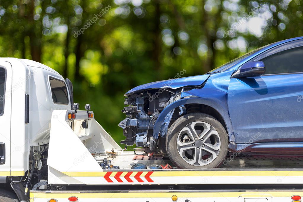 accident Car Slide on truck for move. Blue car have damage by accident on road take with slide truck move . 