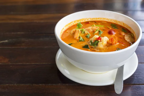 Tom Yam kung baharatlı Tayland çorbası ve ahşap masada karides. Metin veya tasarım için kopyalama alanı ile.