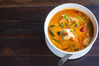 Tom Yam kung baharatlı Tayland çorbası ve ahşap masada karides. Metin veya tasarım için kopyalama alanı ile.