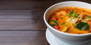 Tom Yam kung baharatlı Tayland çorbası ve ahşap masada karides. Metin veya tasarım için kopyalama alanı ile.