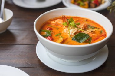 Tom Yam kung baharatlı Tayland çorbası ve ahşap masada karides. Metin veya tasarım için kopyalama alanı ile.