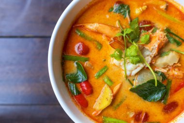 Tom Yam kung baharatlı Tayland çorbası ve ahşap masada karides. Metin veya tasarım için kopyalama alanı ile.