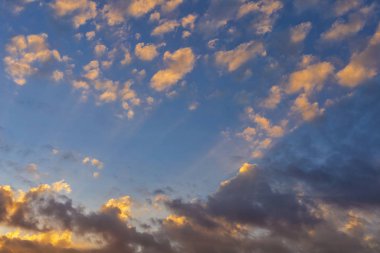 Gökyüzü bulutlu ve güneş ışınlı sarı ve mavi arkaplanlı. Metin veya tasarım için kopyalama alanı ile.