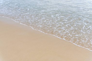 Üst manzara Denizden gelen yumuşak dalga ıslak kumsal arka planına gelir. Metin veya tasarım için kopyalama alanı ile