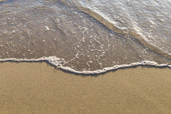 Ovanifrån mjuk våg från havet kommer till våt sand strand bakgrund. Med kopieringsutrymme för text eller design — Stockfoto