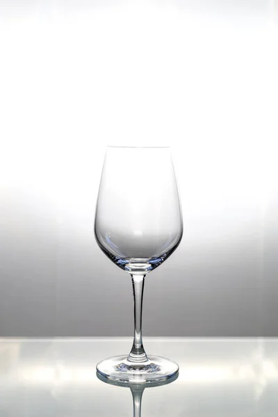 テキストやデザインのためのコピースペースとガラステーブル上の空のワイングラス — ストック写真