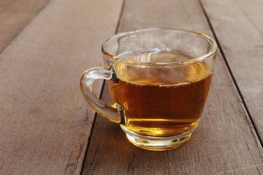 Tahta masadaki sıcak çay fincanını kapat. Metin veya tasarım için kopyalama alanı olan bardakta sıcak çay.