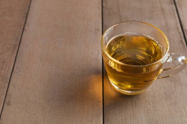 Tahta masadaki sıcak çay fincanını kapat. Metin veya tasarım için kopyalama alanı olan bardakta sıcak çay.