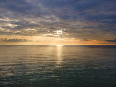 Hava aracı günbatımını deniz üzerinde bulutlu ve güneş ışığını kopya uzayda görüyor..