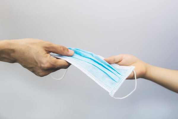 Женщинам дают хирургическую маску. Женщины рука дать медицинскую маску для лица с рукой ребенка для защиты вируса. С копировальным местом. Мать рука дать к хирургической маске с дочерью рукой
.