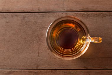 Tahta masadaki sıcak çay fincanını kapat. Metin veya tasarım için kopyalama alanı olan bardakta sıcak çay.