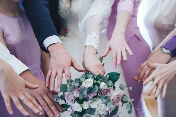 Mains de la mariée et des amis avec le bouquet — Photo