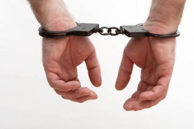 Kelepçeli eller beyaz bir arkaplanda izole edilmiş.