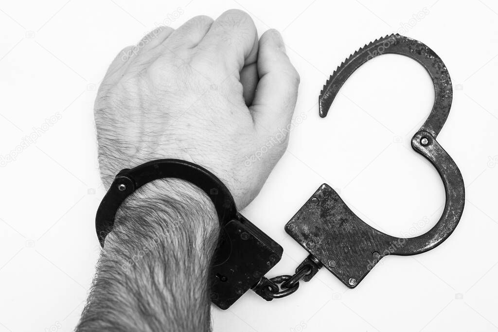 Hand in handcuffs on a white background. Concept of crime and punishment