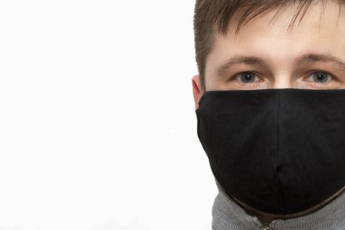 Siyah maskeli bir adam. Virüs ve bakterilere karşı korunmak için el yapımı pamuk yüz maskesi. Salgın bir virüs tacında siyah stil yüz maskesi.