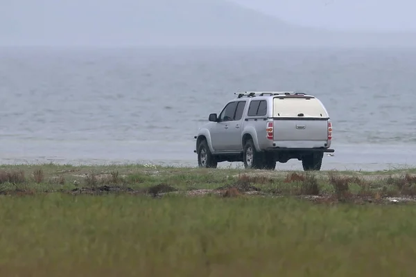 No people, no birds,no way. Alone car stands on the seashore