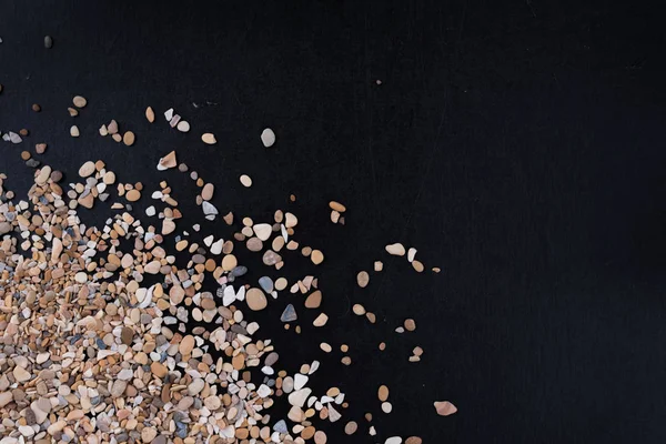 Sıçrama, küçük deniz taşları, köşede bir siyah arka plan, metin, başlık, reklam, menü veya resim altında boş bir alan ile dalga.