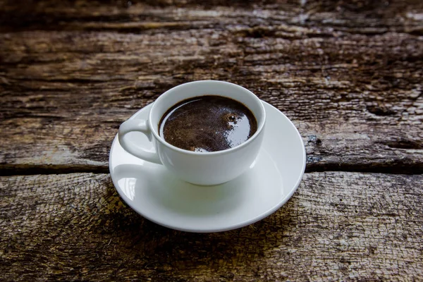Eine Tasse Kaffee auf einem hölzernen Hintergrund — Stockfoto