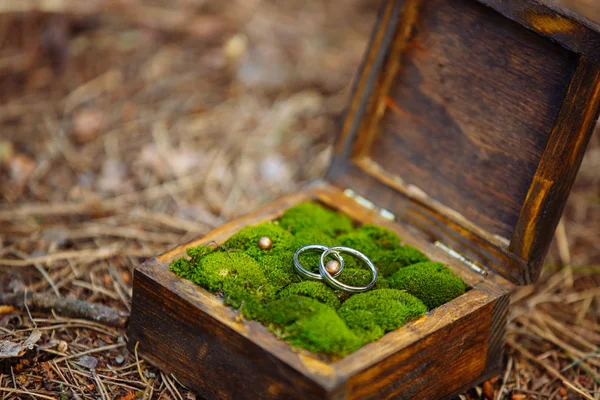 Un par de anillos de compromiso en una caja de madera de cerca. Decoración de boda . — Foto de Stock