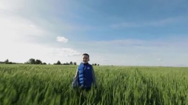 Küçük çocuk çimenlerde koşuyor.