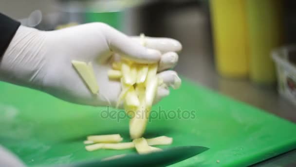 Mão cortando as batatas na cozinha — Vídeo de Stock