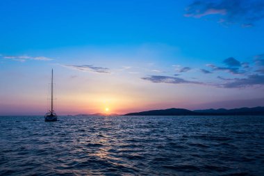 Ufukta bir yelkenli ile denize gün batımı. Deniz ufuk.