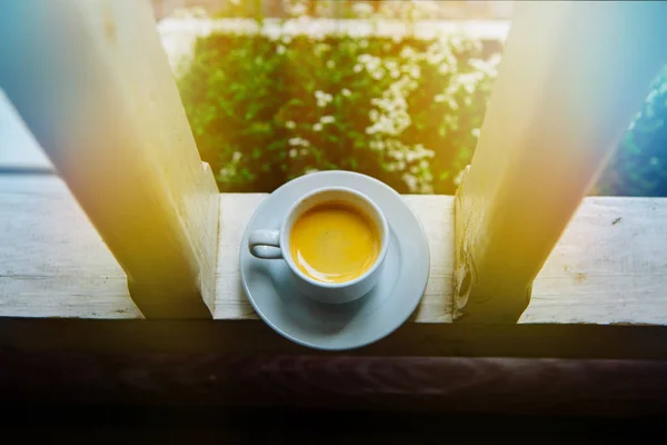 白一碟每天早上喝咖啡在太阳上的玻璃桌上一杯。早上的沙发上家的门廊，蒸汽 — 图库照片