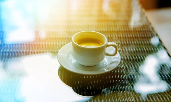 一杯咖啡在早上在太阳上的玻璃桌 — 图库照片