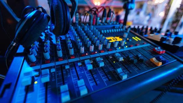 Professional audio mixing console with fader and adjusting knobs - radio / TV broadcasting that hand adjusting audio mixer