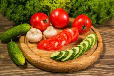 Taze sebze. Domates, salatalık ve bir ahşap tahta üzerinde mantar