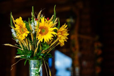 Arka plan sarı ayçiçeği ve buğday kulaklar kahverengi bir arka plan üzerinde bir buket. Metin için yer.