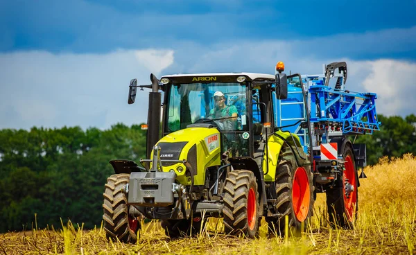 Vinnitsa, Ukraina - juli 2017. En ung jordbrukare på jordbruksmark med en traktor. Jordbruksområdet med grödor vid skörd — Stockfoto