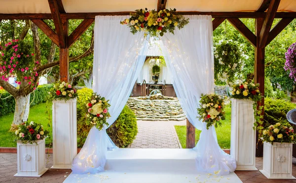 Hermoso arco de boda para la ceremonia en el jardín en tiempo soleado . — Foto de Stock