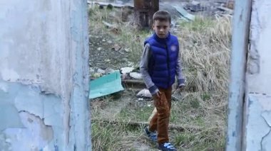 Yalnız çocuk harabelerde dolaşırken