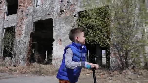 Boy Riding Scooter na fábrica abandonada — Vídeo de Stock