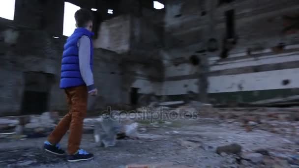 Niño caminar en destruido casa — Vídeo de stock