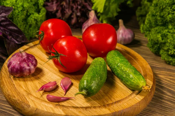 Taze domates salatalık ve sarımsak ile ahşap bir tahta. Taze sebze ile kompozisyon