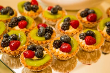 Küçük taze meyve tartlets bir tatlı barda. Güzel kek çilek tablosundaki ile. Taze ekmek. Lezzetli tatlı büfesi ile cupcakes, tiramisu ve diğer tatlılar.