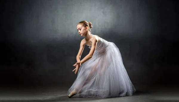 En ung vacker ballerina poserar i studion. En liten dansare. Balett. — Stockfoto